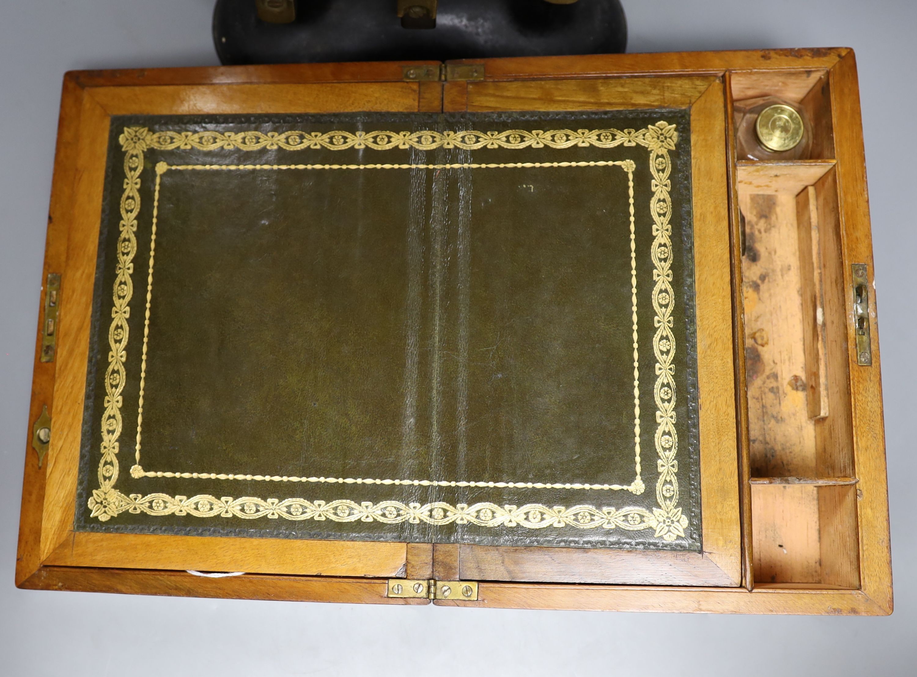 A Victorian walnut writing slope and a set of Victorian cast iron scales and weights (2), writing box 30 cms wide x14 cms high.